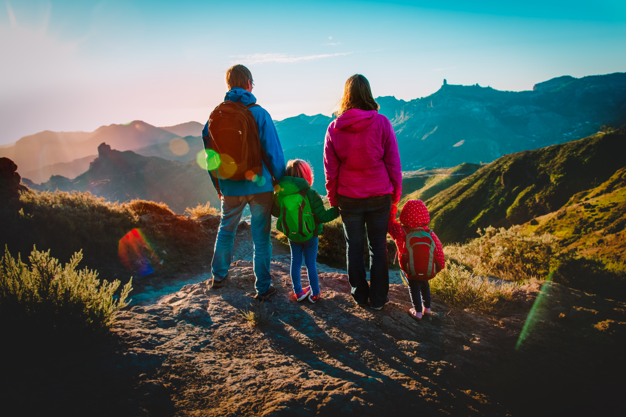 family with kids travel in sunset mountains